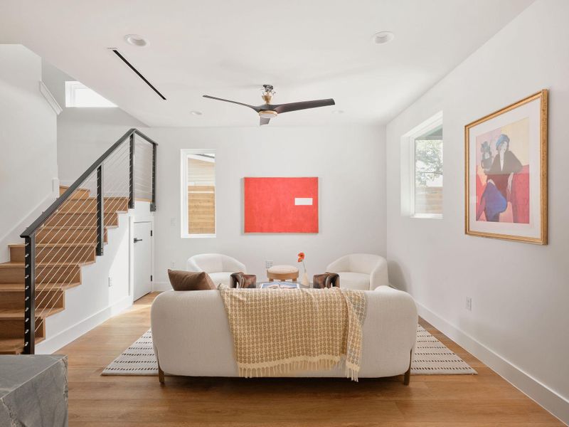 Living room featuring light wood finished floors, stairway, a ceiling fan, and recessed lighting Living room featuring light wood finished floors, stairway, a ceiling fan, and recessed lighting