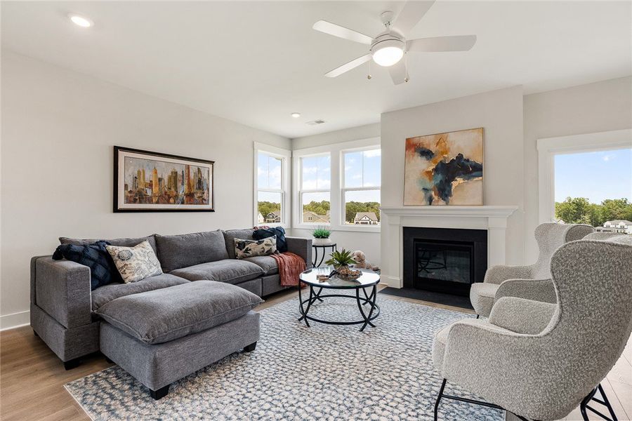 Bright windows and a cozy fireplace define this co Bright windows and a cozy fireplace define this co