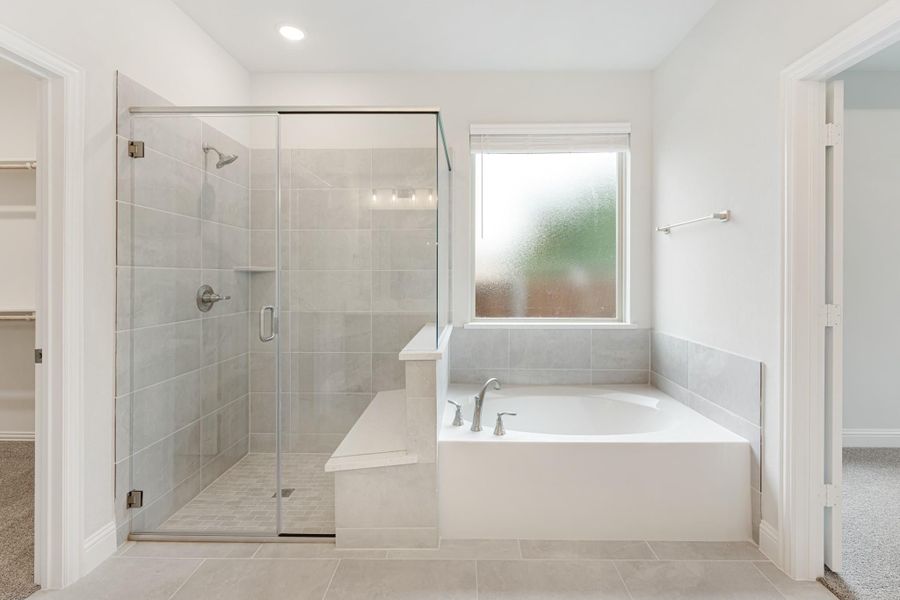Master bathroom with glass-enclosed walk-in shower, soaking tub, and gray tile walls Master bathroom with glass-enclosed walk-in shower, soaking tub, and gray tile walls