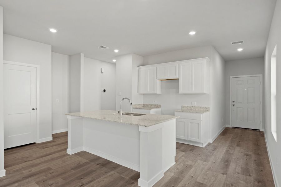A kitchen with white cabinets.