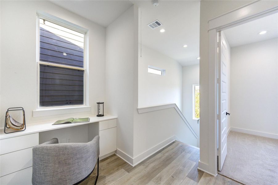 Third floor entry way has a built in desk and drawers for study/office space area.