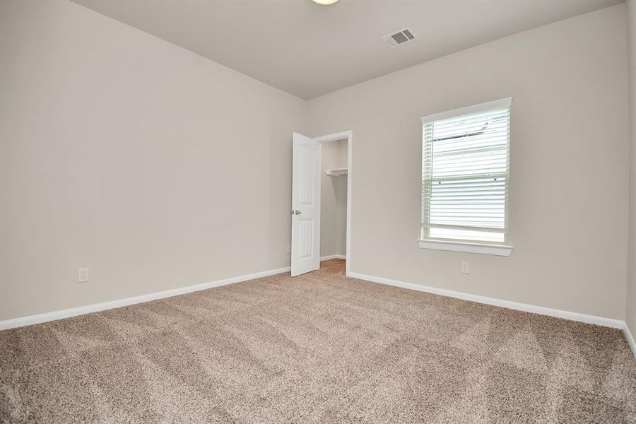 This bright and airy second bedroom offers a versatile space that can easily be transformed to suit your needs. It has ample closet space ensures everything is organized. **This image is from another Saratoga Home with similar floor plan and finishes, not the Brittany floorplan.**