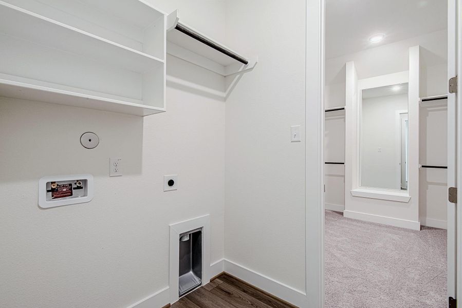 Dedicated laundry room equipped with storage shelving and utility connections Dedicated laundry room equipped with storage shelving and utility connections