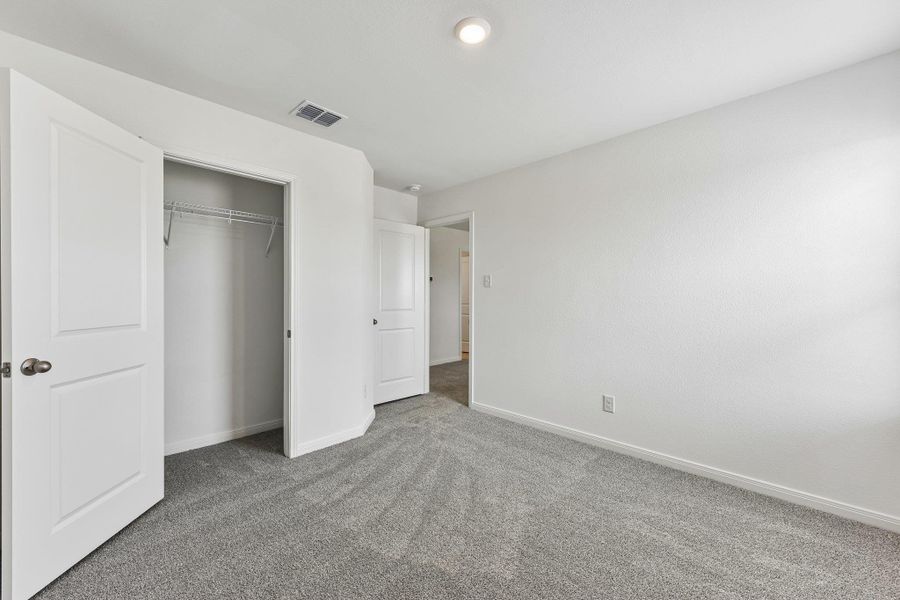 Carpeted room featuring a double-door closet with wire shelving, white interior doors, and recessed ceiling lighting