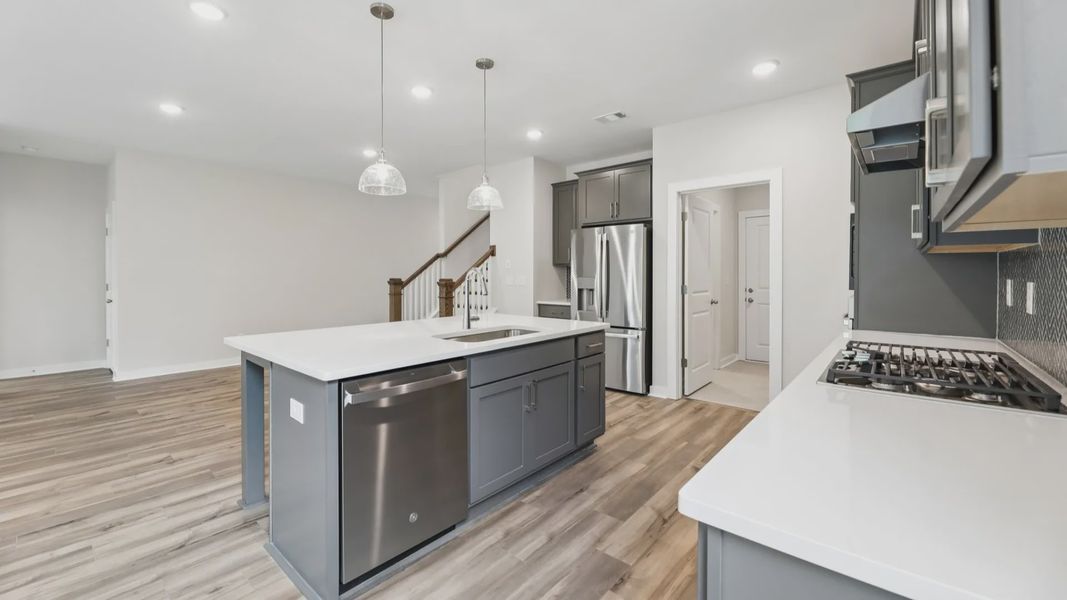 Kitchen with quarts countertops, pendant lighting, and hard surface flooring
