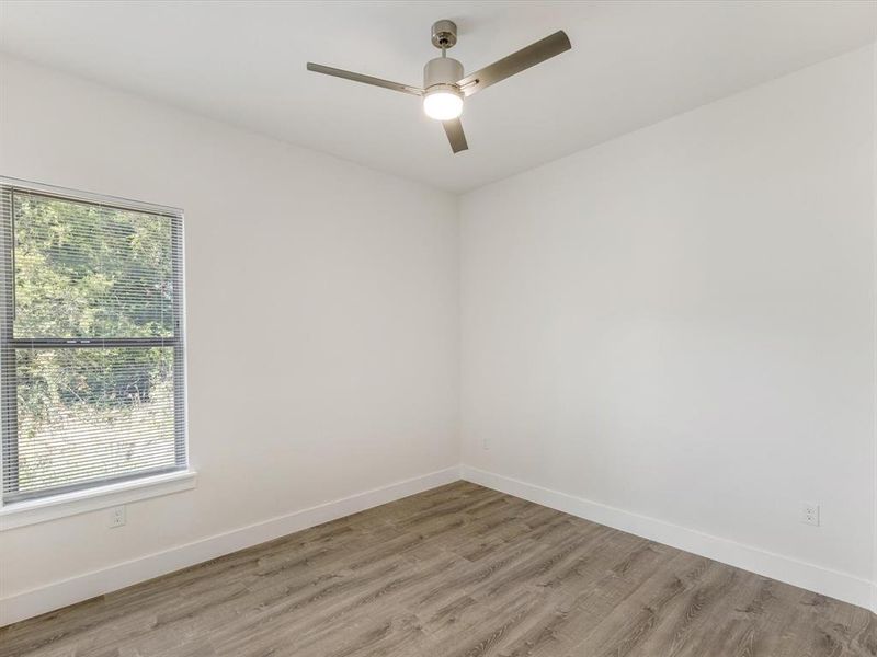 Empty room featuring wood finished floors and a ceiling fan
