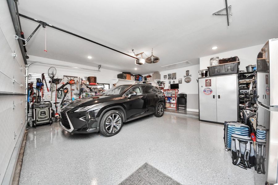 Spacious, well-organized garage with ample storage, sleek epoxy flooring, and room for parking. Ideal for vehicle storage and hobbies.