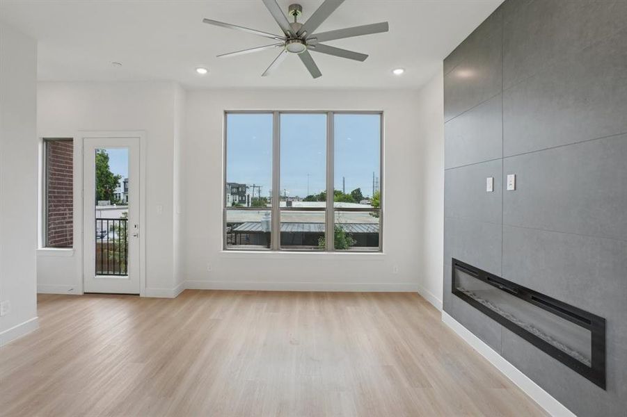 Unfurnished living room with light wood-type flooring, a fireplace, recessed lighting, and ceiling fan