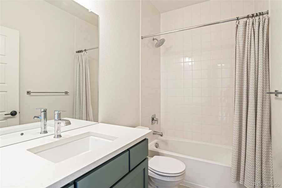 Bright secondary bathroom with quartz countertop vanity, full tub and shower, and clean modern finishes in this Morrison Colorado home