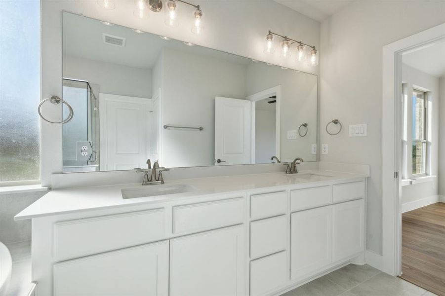 Bathroom featuring vanity, a shower with door, hardwood / wood-style floors, and a wealth of natural light