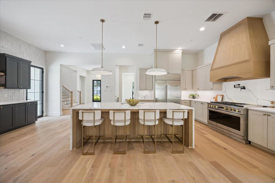 Gorgeous open kitchen with under counter seating, room for table and chairs, accent wall is additional built-ins and shelves. Six burner gas cook top with Pot filler and double oven. Gorgeous open kitchen with under counter seating, room for table and chairs, accent wall is additional built-ins and shelves. Six burner gas cook top with Pot filler and double oven.