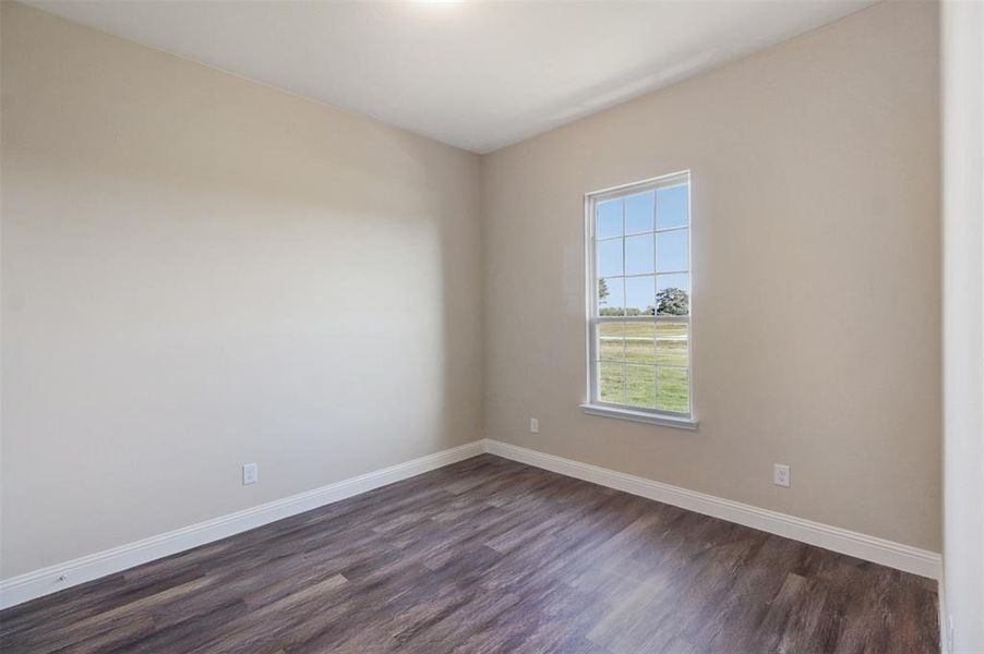 Empty room featuring dark hardwood / wood-style flooring