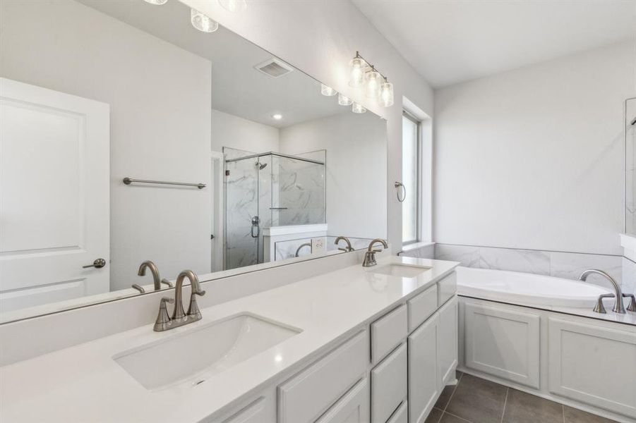 Bathroom with tile patterned floors, separate shower and tub, and vanity