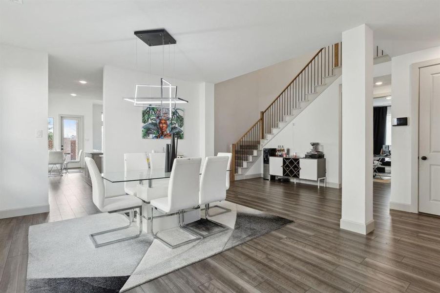 Dining space with stairs, dark wood-style flooring, and recessed lighting Dining space with stairs, dark wood-style flooring, and recessed lighting
