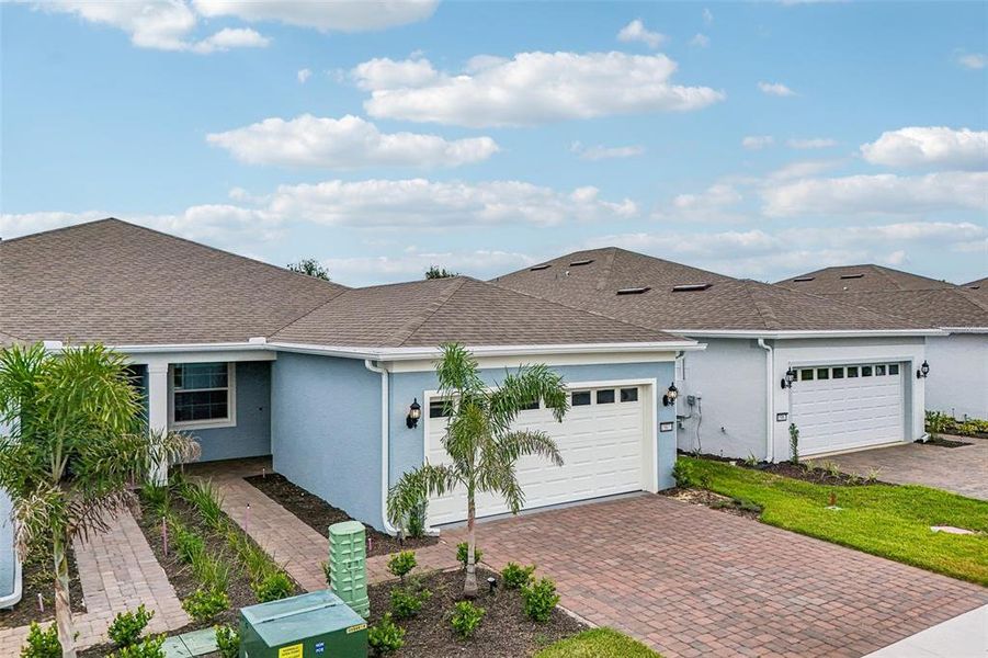 Front exterior of a new home in Del Webb Oasis, Winter Garden, FL, highlighting curb appeal (Image 23). Front exterior of a new home in Del Webb Oasis, Winter Garden, FL, highlighting curb appeal (Image 23).