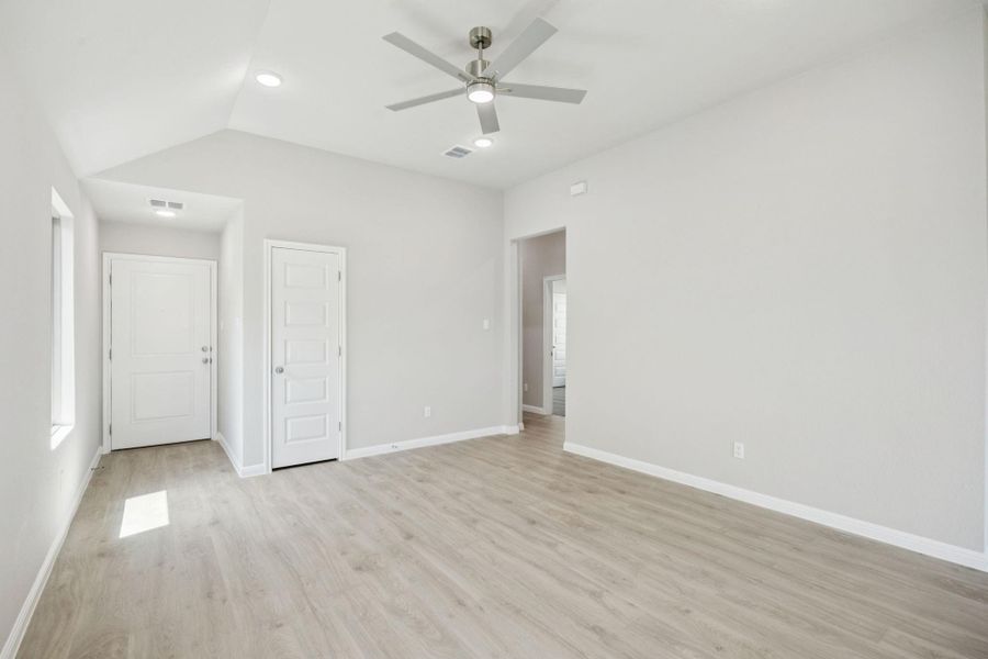 Unfurnished bedroom featuring light wood-type flooring, vaulted ceiling, ceiling fan, and recessed lighting
