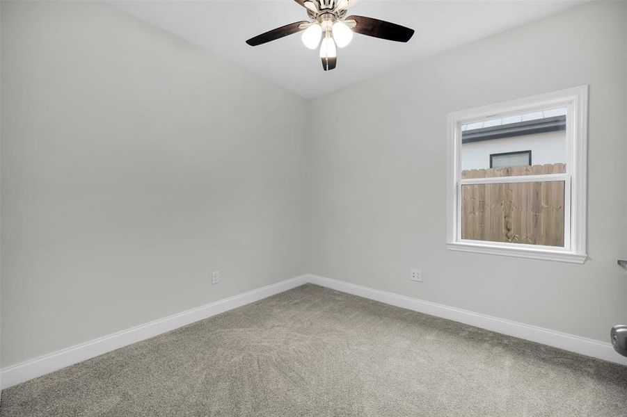 Empty room with baseboards, a ceiling fan, and carpet Empty room with baseboards, a ceiling fan, and carpet