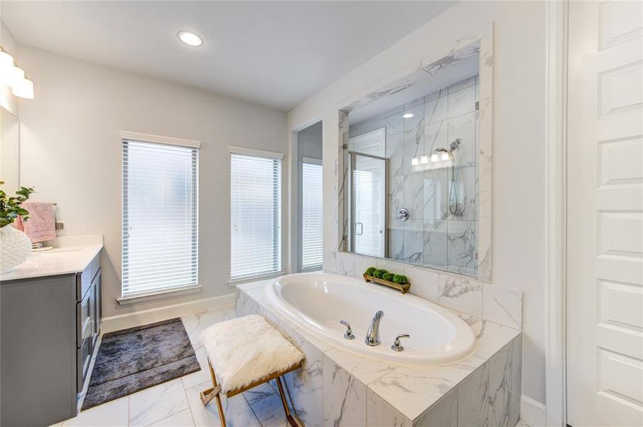 Another view of the primary bathroom with a garden tub and ample walking shower