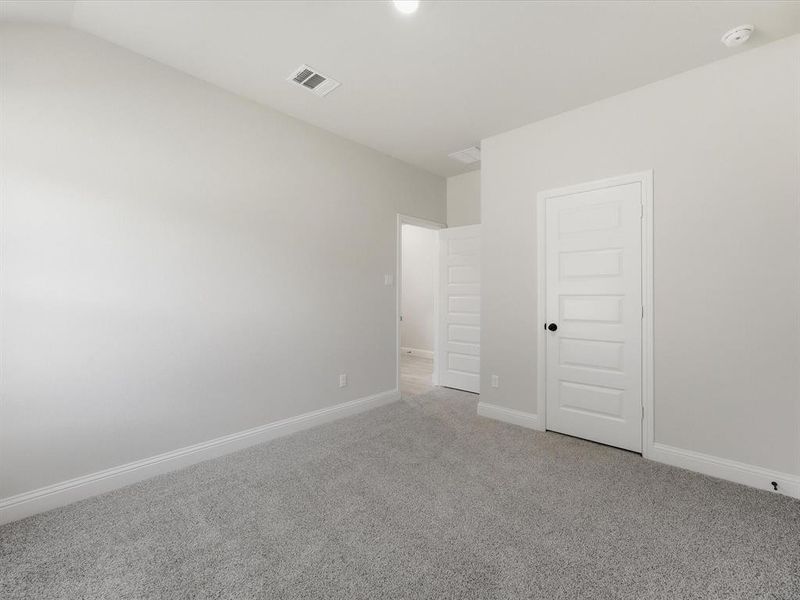 Spacious interior featuring light gray wall paint and gray textured carpet Spacious interior featuring light gray wall paint and gray textured carpet