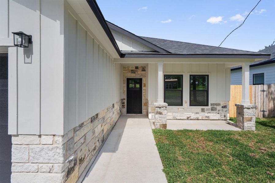 Modern exterior with white board and batten siding and a stone facade