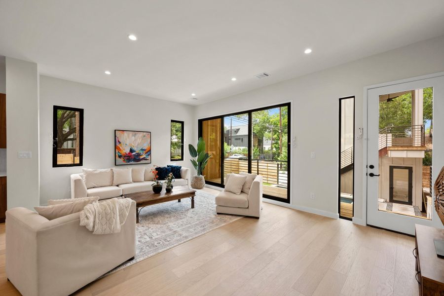 Blonde hardwood flooring and abundant natural illumination elevate this inviting living space. Blonde hardwood flooring and abundant natural illumination elevate this inviting living space.