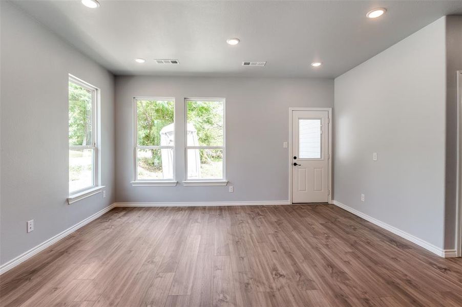 Unfurnished living room featuring a healthy amount of sunlight and hardwood / wood-style floors