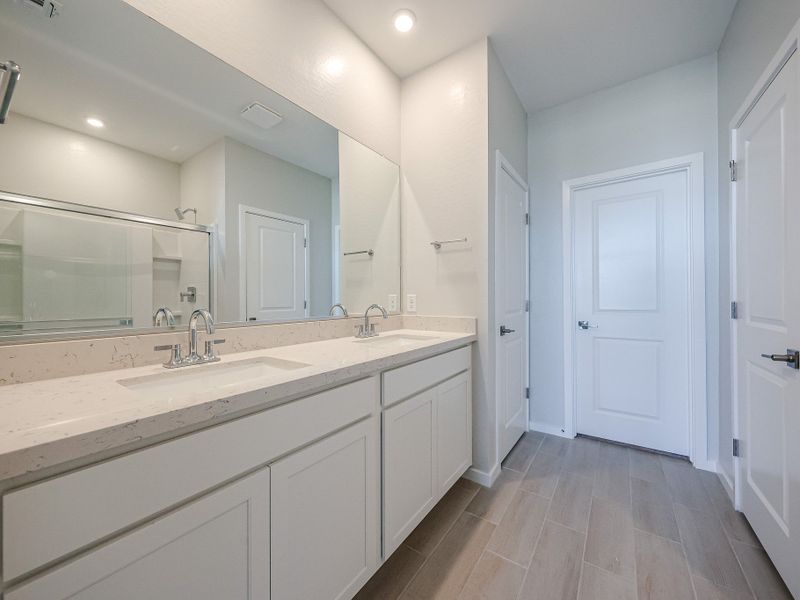A bathroom with white cabinets.