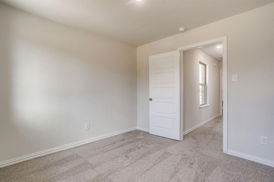 Unfurnished room featuring light carpet and baseboards