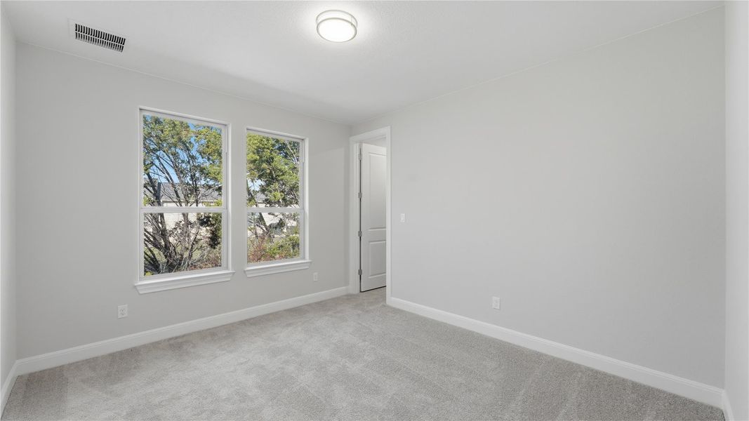 Spare room with light colored carpet and baseboards Spare room with light colored carpet and baseboards