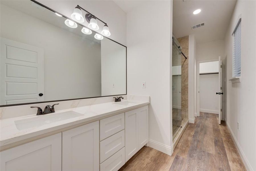 Bathroom featuring vanity, an enclosed shower, and hardwood / wood-style flooring