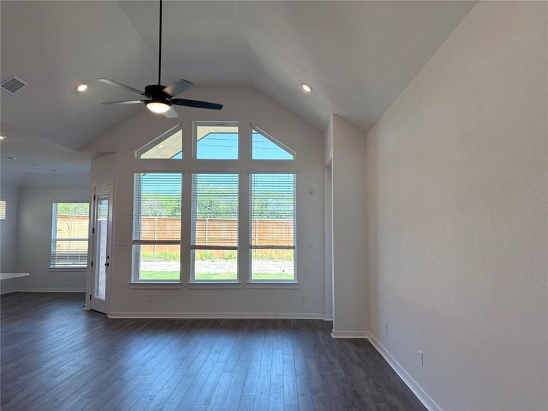 A high vaulted ceiling and tall windows highlight this airy, open-concept living space. A high vaulted ceiling and tall windows highlight this airy, open-concept living space.