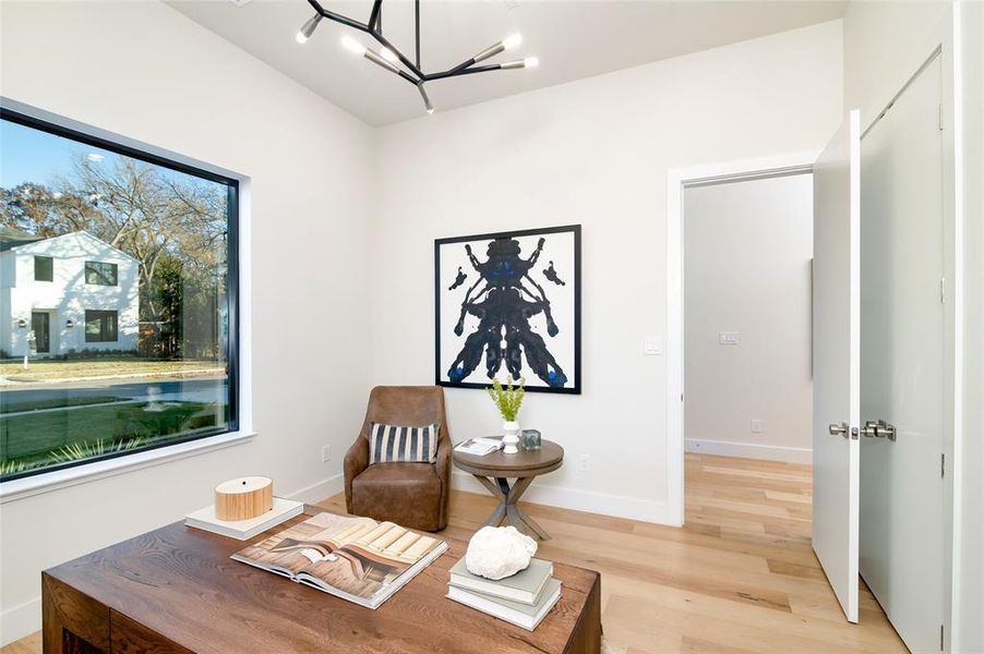 Living area with a notable chandelier and light hardwood / wood-style floors