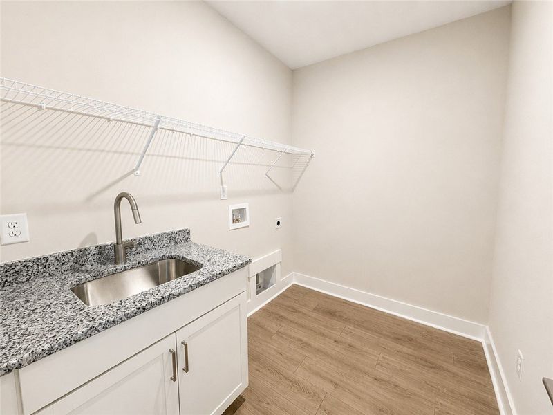 A well-appointed laundry room features granite cou