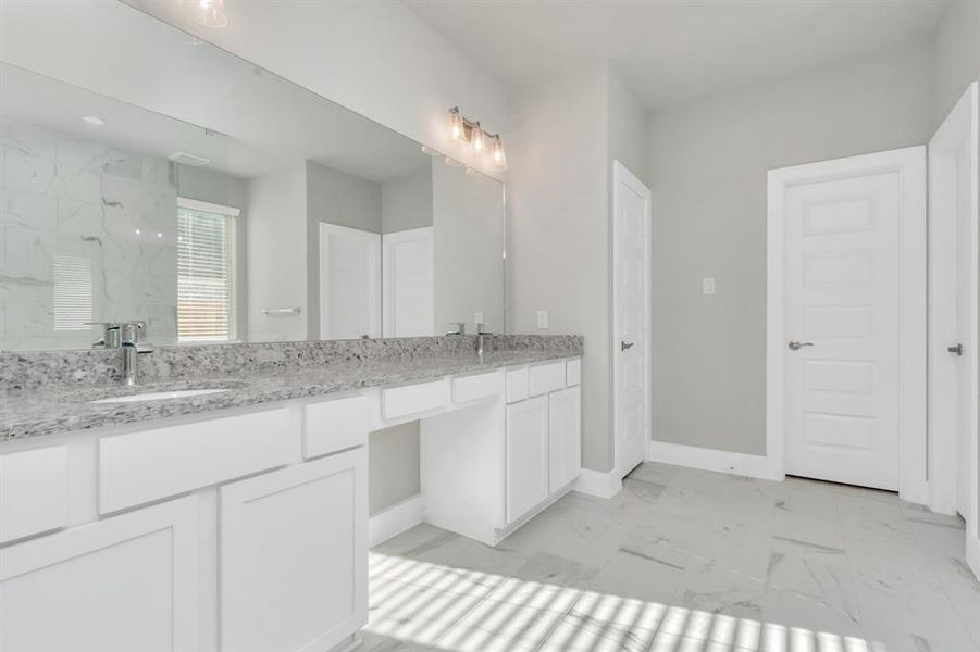 Alternative view of the expansive primary bathroom, showcasing a dedicated vanity area, sophisticated and modern finishes that redefine luxury. Sample photo of completed home with similar floor plan. As-built interior colors and selections may vary.