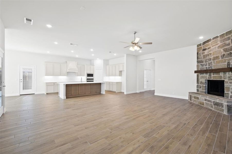 Unfurnished living room with a fireplace, recessed lighting, light wood finished floors, and ceiling fan Unfurnished living room with a fireplace, recessed lighting, light wood finished floors, and ceiling fan