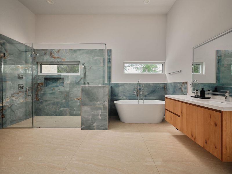 Clean lines define this generous primary bathroom, featuring a freestanding tub and spacious walk-in shower. Clean lines define this generous primary bathroom, featuring a freestanding tub and spacious walk-in shower.
