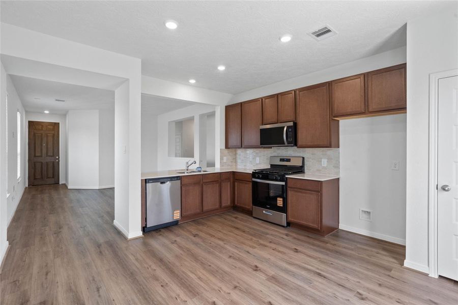Another perspective of this beautiful kitchen and its open views of the Great Room and entryway!