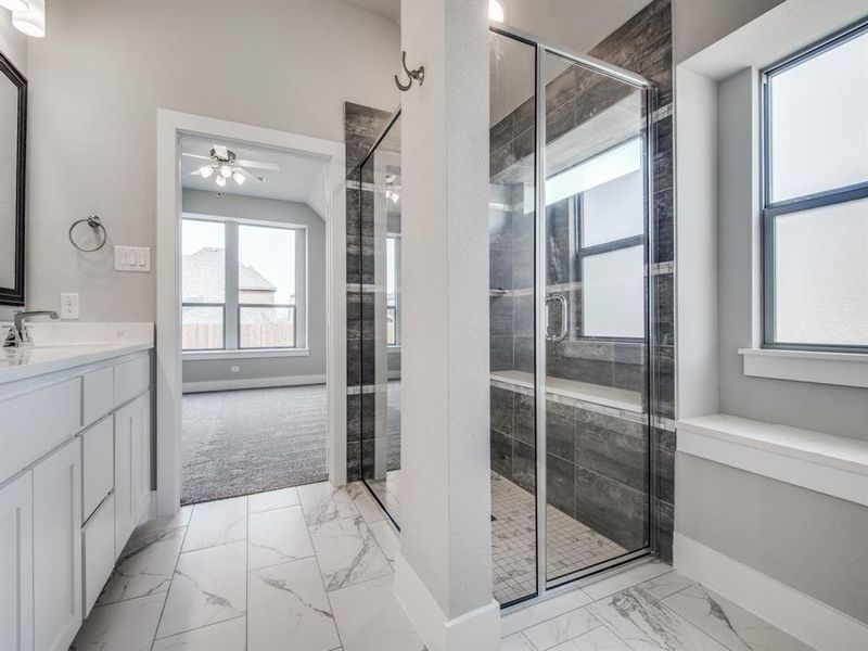 Full bath featuring a ceiling fan, marble finish floor, and a stall shower Full bath featuring a ceiling fan, marble finish floor, and a stall shower