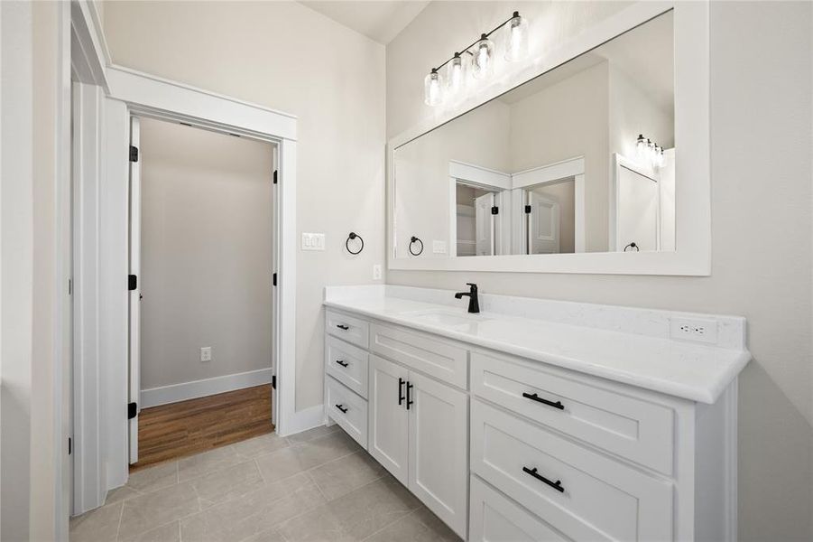 Full bath featuring vanity and light tile patterned floors
