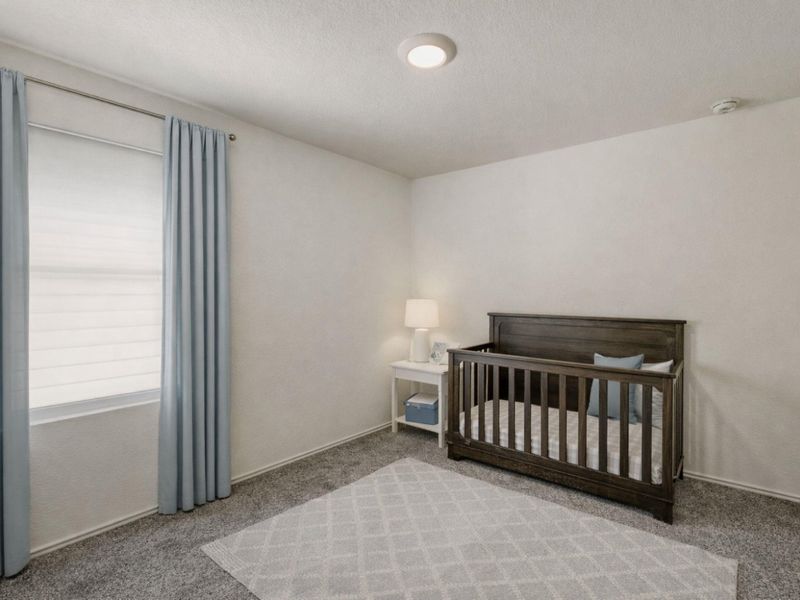 Carpeted bedroom featuring a nursery area and a textured ceiling