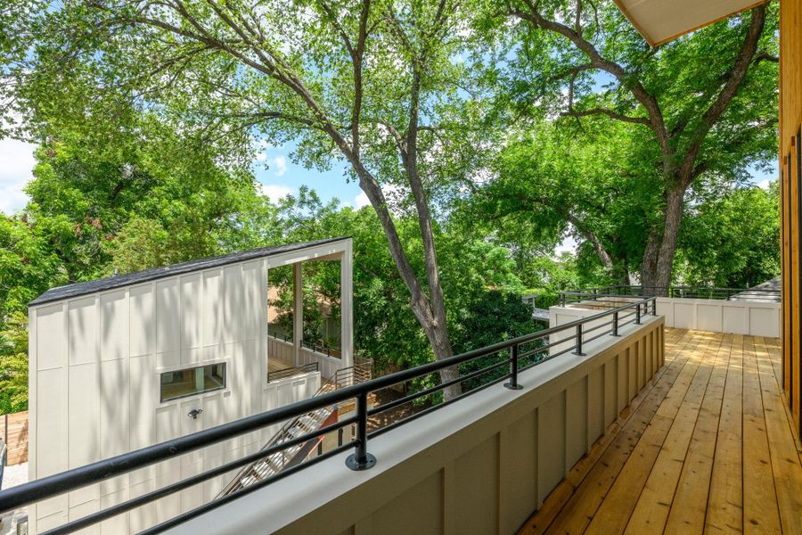 A spacious rooftop deck provides a serene outdoor living area amidst lush green trees. A spacious rooftop deck provides a serene outdoor living area amidst lush green trees.