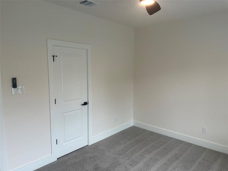 Carpeted empty room featuring ceiling fan