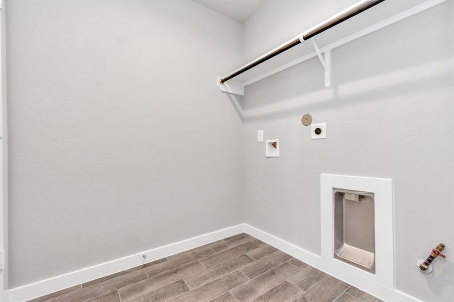 A perfect blend of functionality and comfort. Laundry room, thoughtfully equipped with shelving for effortless organization. Both gas and electric connections available.  Sample photo of completed plan. As-built color and selections may vary.