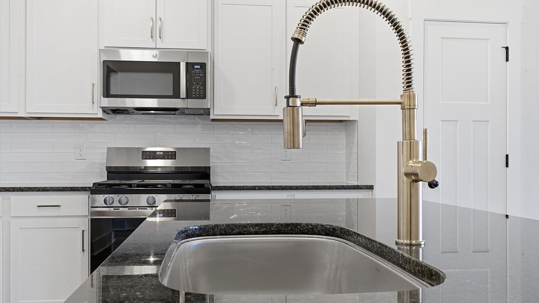 Well-designed kitchen with a center island and tasteful finishes that elevate everyday living by DRB Homes