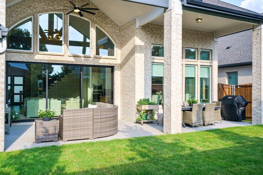 Indoor-Outdoor Harmony - This view from the yard highlights the massive glass sliders and transom windows that visually connect the indoor living space with the shaded patio retreat. Indoor-Outdoor Harmony - This view from the yard highlights the massive glass sliders and transom windows that visually connect the indoor living space with the shaded patio retreat.