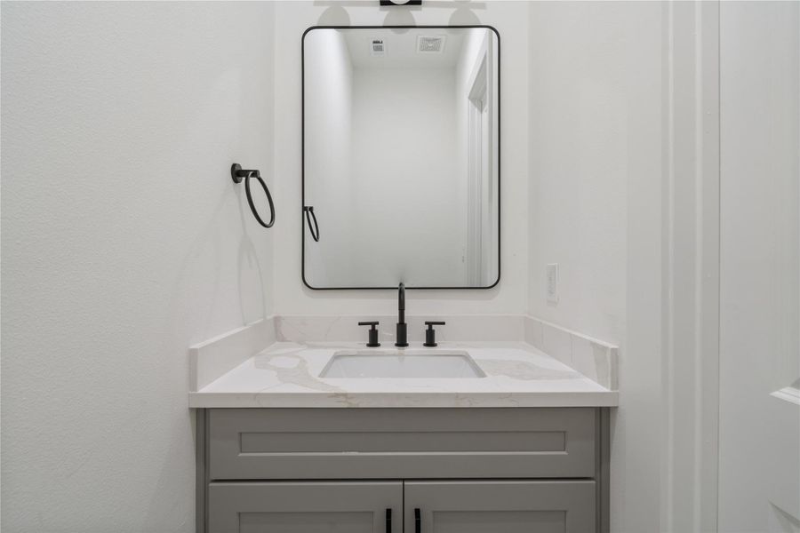 The powder room is thoughtfully tucked away from the living area and kitchen, providing privacy and convenience for guests. Its discreet location keeps the main spaces open and uncluttered. This design adds both functionality and a polished touch to the home.