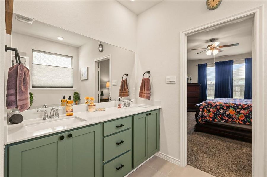 Ensuite bathroom with double vanity, a ceiling fan, and tile patterned floors Ensuite bathroom with double vanity, a ceiling fan, and tile patterned floors