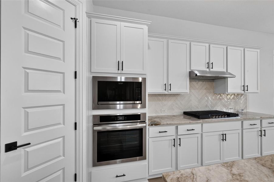 Elegant crown molding complements modern cabinetry and integrated stainless steel appliances in this kitchen. Elegant crown molding complements modern cabinetry and integrated stainless steel appliances in this kitchen.