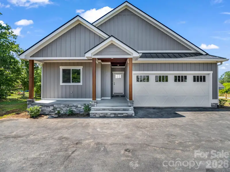 Front view of custom modern farmhouse, 2 car attached garage, covered front porch and hardyboard siding Front view of custom modern farmhouse, 2 car attached garage, covered front porch and hardyboard siding