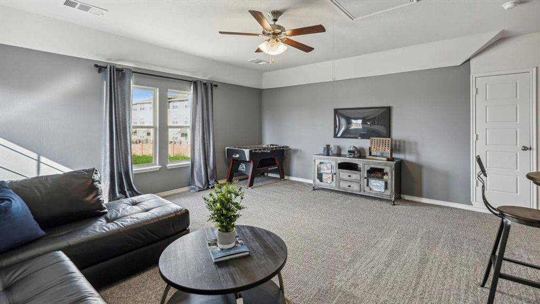 The property features a spacious room with carpeted flooring, two windows providing natural light, and a ceiling fan